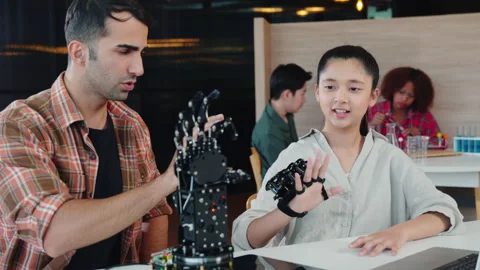 In a classroom teacher assists student in building a robotic arm for design and Stock Footage 275581698