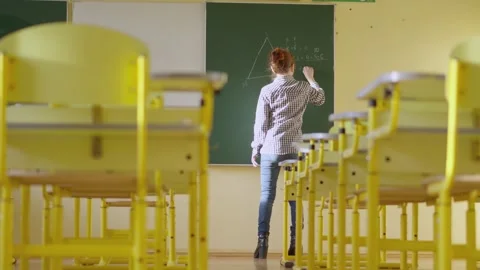 In a classroom, a teacher utilizes a blackboard to impart geometry lessons Stock Footage 277932110