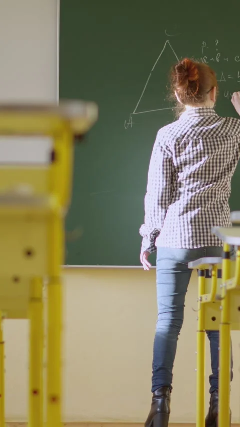 In a classroom, a teacher utilizes a blackboard to impart geometry lessons Stock Footage 279218092