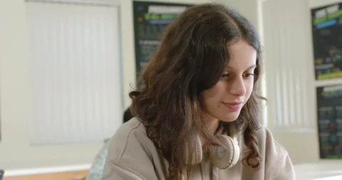 Classwork causing teenage female student studying at desk in classroom, wearing Stock Footage 340656088