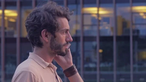 Classy dressed man calling on a phone while waiting for a meeting outdoor Stock Footage 132979379