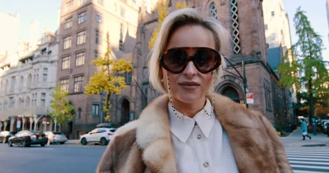 Classy elegant blonde lady outdoors. Beautiful woman wearing white shirt, fur Stock Footage 332244715
