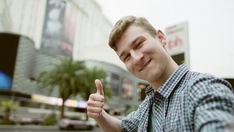 Classy guy is holding the camera in front of himself and pointing at the Eiffel Stock Footage 76238923
