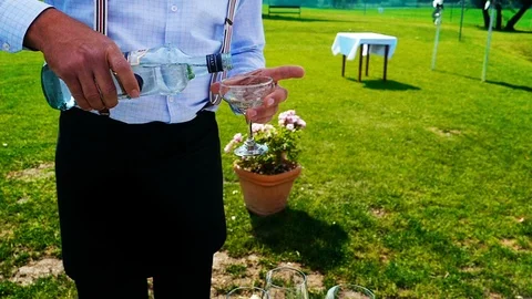 Classy Waiter Pours A Drink At Open Air Celebration, Slow Motion Stock Footage 96527093