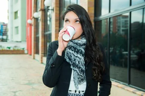 Classy woman wearing dark coat and white black scarf in urban environment 스톡 사진
