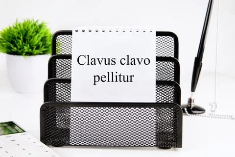 Clavus clavo pellitur. The ancient Greek expression translates as, A wedge is Stock Photos