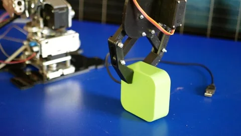 The claw clamp with a servo motor grabs a rectangular load and starts moving 스톡 동영상 305394112