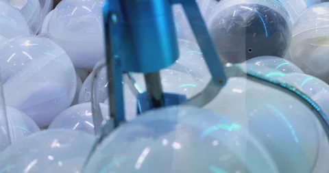 Claw crane game skillfully retrieving colorful toy capsules Stock Footage 293093518