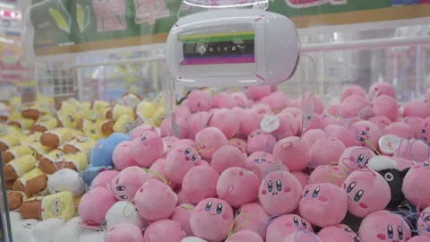 Claw machine attempts to grab pink Kirby plush toy Stock Footage 233107704