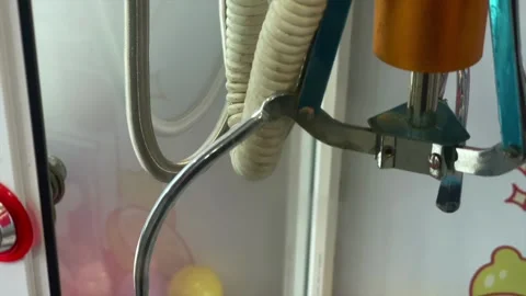 Claw machine crane grabbing prize capsule in arcade Stock Footage 340483924