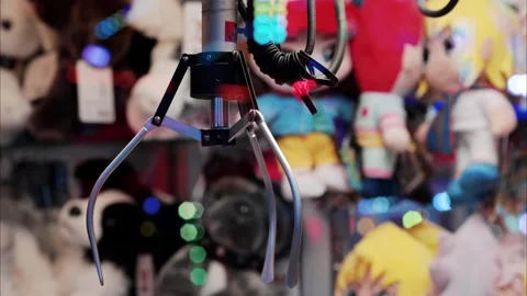 A claw machine game with colorful lights and soft toys in a fun arcade sett.. Stock Footage 339116846