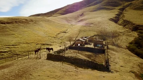 Clay authentic mountain House during sunset and horses, Dolly aerial shot Stock Footage 89811171