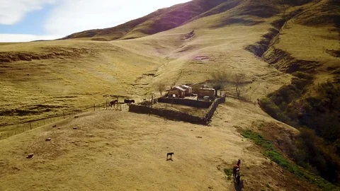 Clay authentic mountain House during sunset and horses, DRONE aerial shot Stock Footage 89811285