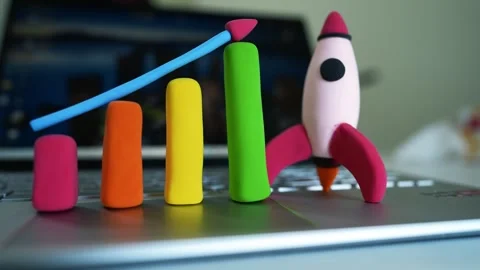 Clay Bar Graph and Rocket on Laptop Symbolizing Growth, Colorful clay bar g.. Stockbeeldmateriaal 304881740