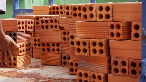 Clay bricks are lifted and organized into a truck, showing the physical effort Stock Footage 313668481