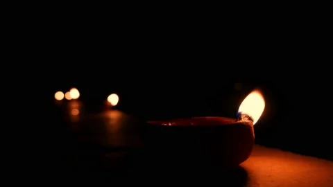 Clay diya lamp with flames closeup isolated against other burning diya Stock Footage 164509750