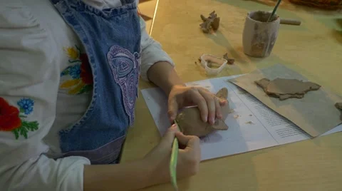 Clay Dolphin is Made by a Fine Looking Small Blonde Girl Who Uses a Wooden Stock Footage 59129635