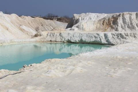 Clay mining. Beautiful background of white clay. Blue water. Stock Photos