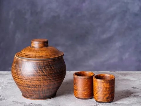 Clay pot and two empty ceramic cups on a rustic background Stock Photos