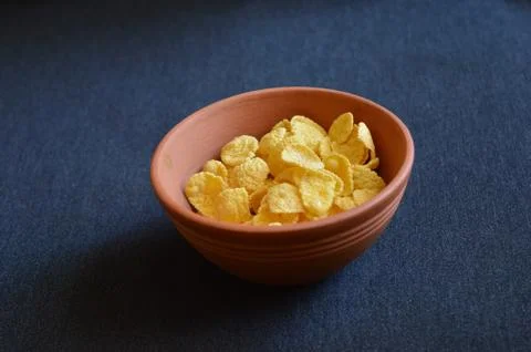 Clay pot of corn chips on a black background Stock Photos