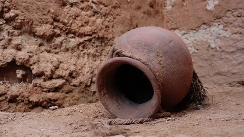 Clay pot lying on its side against mud wall 動画素材 347973322