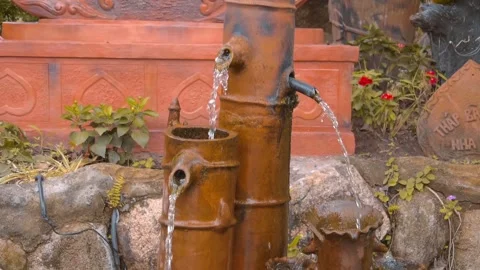Clay pots and bamboo stems with water flowing from them is traditional fountain  Stock Footage 303302573