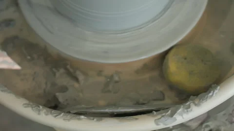 Clay residue scene. Potter working beside sponge. Quiet studio with potter and Stock Footage 342282889