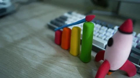 Clay Rocket and Bar Graph on Desk, Colorful clay rocket and bar graph on a .. Stock Footage 304881343
