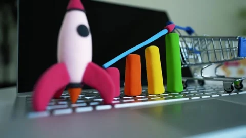 Clay Rocket and Bar Graph on Laptop Keyboard, Colorful clay rocket and bar .. Stock Footage 304881645