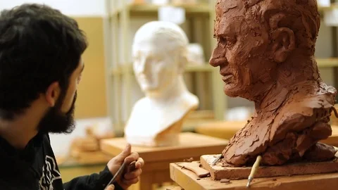 Clay sculptor making a clay bust in an art studio Stock Footage 124981133