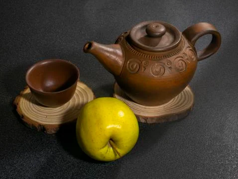 Clay teapot and clay cup and apple Stock Photos