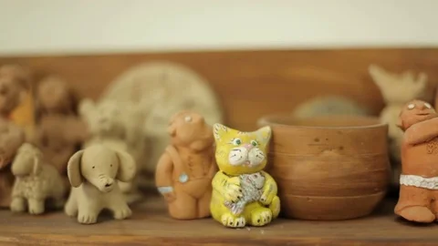 Clay toys and souvenirs stand on the shelf. Handmade folk art Stock Footage