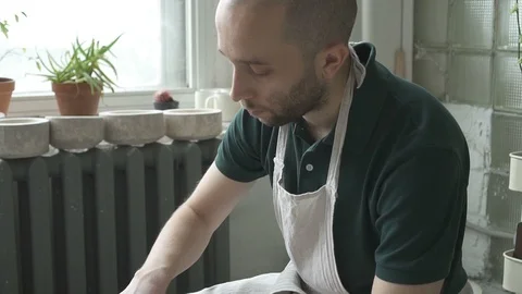 From clay on wheel in workshop man is engaged in pottery art. Video stock 87325079