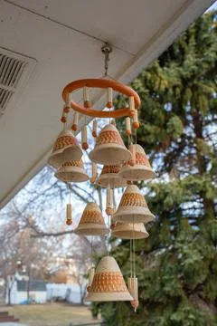 Clay wind chimes hanging under roof of house Foto stock