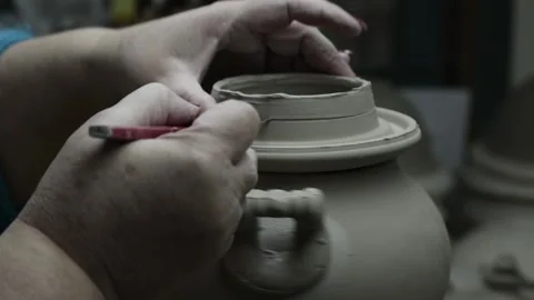 Clay workshop. The hands of an elderly woman cut off the edges of the lid on Video stock 130526331