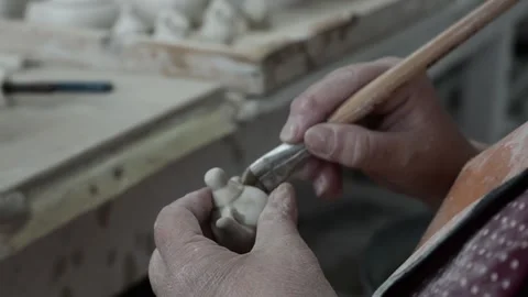 Clay workshop. Womens hands are protected by a wet sponge and brush roughnes Video stock 130526352