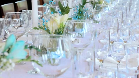 Clean and empty sets of four glasses stand next to plates and textile napkins on Stock Footage 253323628