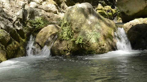 Clean and fresh water from a stream flowing between rocks. Stock Footage 135605490
