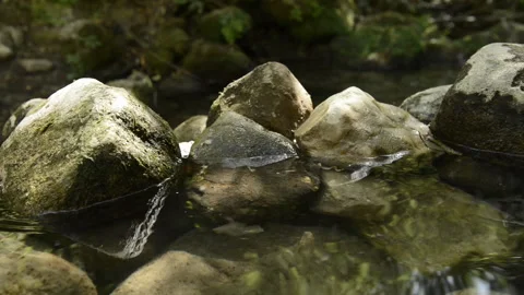 Clean and fresh water from a stream flowing between rocks. Stock Footage 135605867