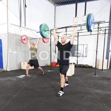 Clean and jerk workout at fitness gym center Stock Photos