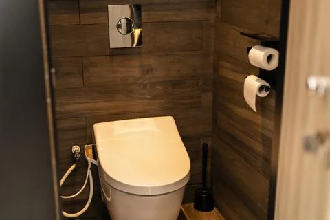 A clean and simple bathroom setup shows a toilet with a bidet feature and t.. Stock Photos