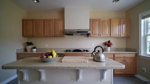 Clean and spacious kitchen design featuring a central island, granite Stock Footage 335786222