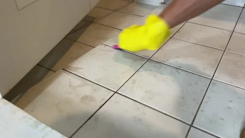 Clean bathroom floor white ceramic tile brushing dirt mold by hand wear glove Видео 187618638