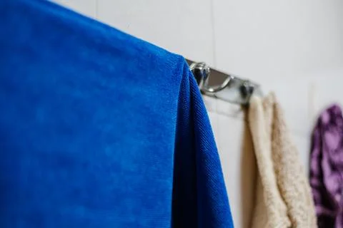 Clean blue towel, hanging on the wall Stock Photos