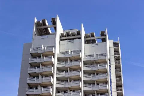 Clean close-up shoot of multi-storey concrete building with blue background Stock Photos