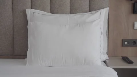 Clean comfortable hotel room interior with soft pillows on bed and modern b.. Vídeos de archivo 332263271