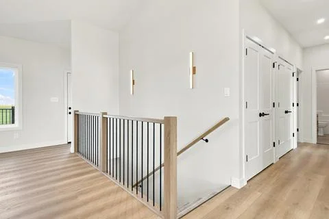 Clean, contemporary home space with light wood flooring and white walls Ilustração Stock