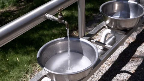 Clean Drinking Water Flowing from Public Tap Into Metal Sink Outdoors Stock Footage 339087014
