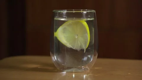 Clean drinking water with lemon floating in it in a transparent glass. Stock Footage 249010114