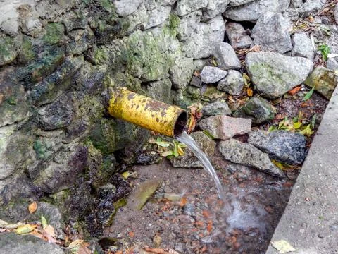 Clean drinking water spring flows from the pipe Stock Photos